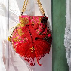 "Red Fish" is a small embroidered bag inspired by Japanese Hanfu fashion. Adorned with a magnificent goldfish adorned with jewels, this purse is made as a unique piece. Embroidered with flowers and pearls. The chain is made of gold beads and imitation mother-of-pearl. This pouch closes with sliding ties. Two pompoms with bells complete the original design of this bag. Bag for a boho wedding, for your evenings or your days, dare to wear it on all occasions. It can also be used as a jewelry or makeup bag. Dimensions: - 23X23 cm (add 5 cm for the total dimension with the fish tail) - 47 cm pearl chain Holds a medium sized cell phone and wallet. Ideal for making a unique and precious gift. Your grigri will be delivered directly from my hands to yours, with care and attention. - Maintenance tip Pink Bags For Evening And Festivals, Red Shoulder Bag For Festive Gift, Festive Red Shoulder Bag As Gift, Festive Red Shoulder Bag For Gifts, Red Embroidered Potli Bag For Party, Traditional Red Party Bag, Red Rectangular Evening Bag For Festivals, Red Embroidered Party Bag, Elegant Embroidered Red Potli Bag