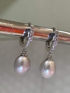 These are the earrings Kate Middleton Wears casually, We replicate them in detail, from pearl shape & size They are made of natural gray Pearl (akoya) with Melee Sized Diamonds Sterling Setting. 925 Stamp setting. Exceptional quality pearl with beautiful luster and brilliant nacre. You can see reflection off the pearl. We also pay attention to detail. Like Kate's earrings... You will also notice there's no hole on the bottom of the pearl, (no posts stick out of bottom like you see on many lo Elegant Oval Pearl Earrings With High Luster, Pear-shaped Akoya Pearl Silver Earrings, Luxury Oval Pearl Drop Earrings, Luxury Silver Teardrop Pearl Earrings, Silver Akoya Pearl Drop Earrings, Formal Silver Pearl Diamond Earrings, Silver Diamond Dangle Earrings With Pearl Drop, Silver Akoya Pearl Earrings With Pearl Charm, Formal Silver High Luster Pearl Earrings