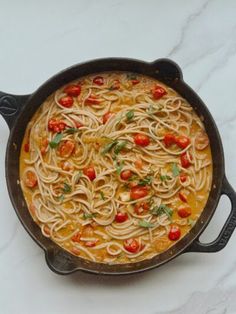 a skillet filled with noodles and tomatoes