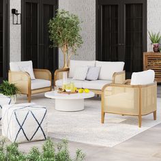 an outdoor living room with wicker furniture and potted plants