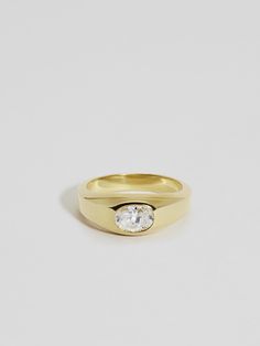 a gold ring with a single diamond on the top and bottom, against a white background