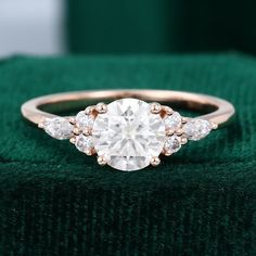 a diamond ring sitting on top of a green cloth