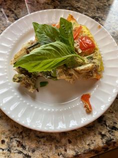 a white plate topped with an omelet covered in veggies