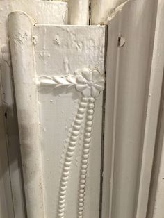 a white door handle with beads hanging from it's side and on the outside