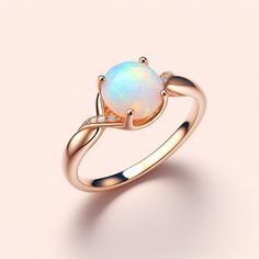 an opal and diamond ring on a pink background