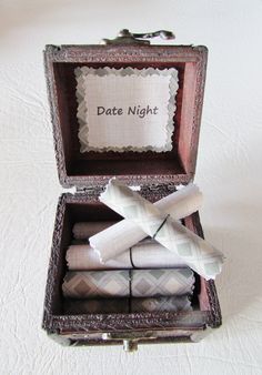 an open box with folded napkins in it on top of a white tablecloth