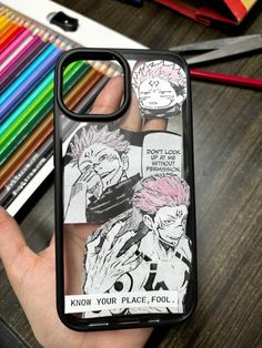 someone is holding up their phone case with the anime characters on it and colored pencils in the background