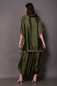 Dark olive green kaftan style tunic, highlighted with hand embroidered yoke. Paired with an overlapping dhoti pant.
Components: 2
Pattern: Hand Embroidered Yoke
Type Of Work: Flower Mandala
Neckline: V Neck
Sleeve Type: Three Quarter Sleeves
Fabric: Silk Chanderi, Silk
Color: Green
Other Details: 
Beaded fringe detailing on the yoke
Golden sequin coin lace detailing
Occasion: Mehendi and Haldi - Aza Fashions Coin Lace, Green Kaftan, Kaftan Tunic, Embroidered Kaftan, Dhoti Pants, Kaftan Style, Pant For Women, Dark Olive Green, Beaded Fringe