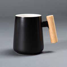 a black coffee mug with a wooden handle