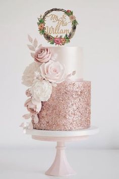 a three tiered cake with pink and white flowers on top