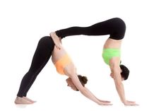 two women doing yoga poses on their hands