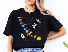 a woman wearing a black shirt with planets on it