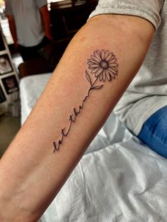 a person with a tattoo on their arm that reads,'faith'and has a flower in it