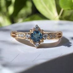 a blue and white diamond ring sitting on top of a table