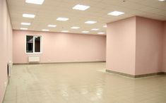 an empty room with pink walls and white tiles