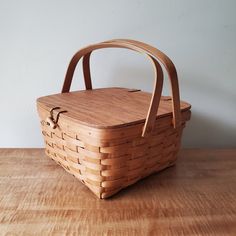 a basket sitting on top of a wooden table next to a white wall and floor