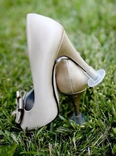 a pair of white shoes sitting on top of a green grass covered field with the caption, these nozzles for shoe heels can't deffren your shoes with grass and soil