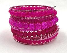 This hot pink wrap bracelet is made on silver memory wire with 12 vibrant rows of glass beads in various shapes and sizes.  ★ Return to my main shop page here for more inventory ★ www.etsy.com/shop/bridgetollbeading ★ Read my FAQ's below and if you have any further questions please do not hesitate to contact me! ★ https://www.etsy.com/shop/BridgeTollBeading?ref=hdr#more-section Adjustable Pink Multi-strand Beaded Bracelets, Pink Adjustable Multi-strand Beaded Bracelets, Pink Wire Wrapped Beaded Bracelets With Round Beads, Pink Multi-strand Beaded Bracelets, Handmade Pink Wrap Bracelet With Round Beads, Pink Wrap Bracelet With Round Beads, Pink Hand Wrapped Wrap Bracelet With Round Beads, Pink Multi-strand Beaded Bracelets Gift, Bohemian Pink Wire Wrapped Beaded Bracelets