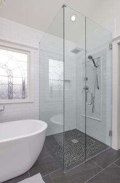 a white bath tub sitting next to a walk in shower