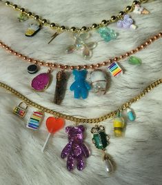 These cute chunky charm necklaces are super adorable and feature Crystal Gemstones on the copper necklace 💜 The copper necklace includes an oreo, Rainbow moonstone, teddy bear gummy, Tiger eye Pendulum, Pink Agate, slice of cake and green freeform jelly. Top necklace has a chunky plastic gold necklace includes some icecream pendants, butterfly, jelly dog and thunder bolt pendants  Bottom necklace  has a gold Cuban Link Chain and features a Victorian beetle pearl pendant, jelly bear, ice-cream, Lollipop, cake, locket and medicine pill All crystals are Sun Cleansed to purify & infused with positive energy. All stones are  Ethically Sourced Gemstones and ship from beautiful Pennsylvania. Crystal Chunk Necklace, Chickasaw Necklace, Trendy Handmade Charm Necklaces As Gift, Fun Charm Necklaces For Gifts, Fun Charms Jewelry As Gift, Fun Charms Jewelry For A Gift, Unique Metal Charm Necklaces, Handmade Whimsical Choker Jewelry, Cute Nickel-free Metal Charm Necklaces