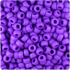 purple plastic beads are stacked together in a pile