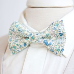 "Dapper Men's Bouquet In Blue Bow Tie Made By The Belle And The Beau! Our dapper, modern, stylish, and charming neckties are perfect for everyday, Sunday best, all special occasions, photography sessions, and especially dapper on grooms and groomsmen! They are the perfect wedding accessory. We use the best cotton and cotton blend fabrics. We love that cotton is so versatile to dress up or down for any occasion. Each bow tie has a double layer for a dapper and preppy look. You have your choice of Blue Floral Bow Tie, Light Blue Bow Tie, Man Bouquet, Rustic Wedding Gifts, Groomsmen Bowtie, Floral Necktie, Fabric Hair Bows, Floral Bow Tie, Ring Bearer Outfit