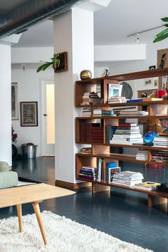 a living room filled with lots of books and furniture