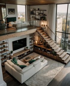 a living room filled with furniture and lots of windows next to a stair case in front of a large window