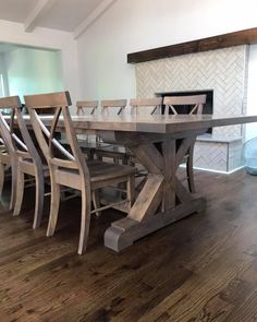 a dining room table with six chairs and a fireplace in the backround area