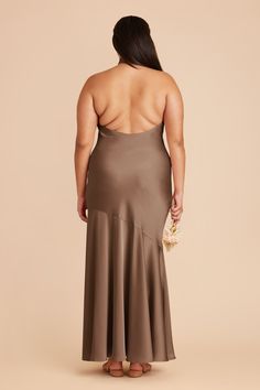 a woman in a brown dress with her back to the camera