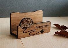 a wooden business card holder with a brain on it