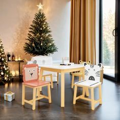 two children's chairs sitting at a table in front of a christmas tree