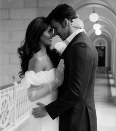 a man and woman in formal wear standing next to each other with their arms around each other