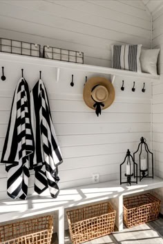 the sun shines on an outdoor bench with baskets and hats hanging from it's hooks