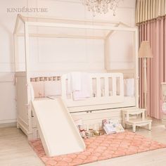 a baby's room with a white crib and pink rug