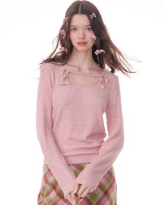 a woman in pink sweater and plaid skirt