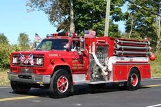 a red fire truck driving down the road