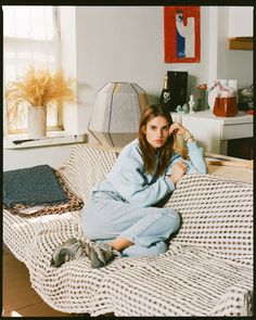 a woman sitting on top of a bed in a room