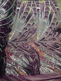 the back of a purple dress with sequins and feathers on it's side