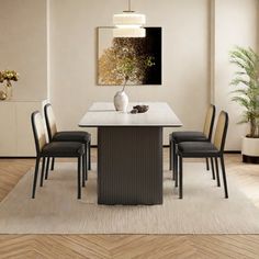 a dining room table with four chairs and a vase on the centerpiece in front of it