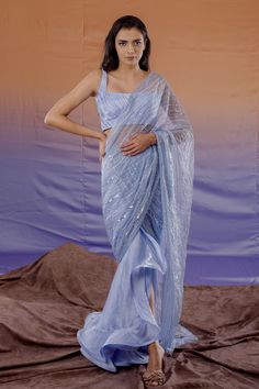 Powder blue satin draped saree with embroidered pallu on organza and ruffle detail. Paired with pleated blouse.
Component: 2
Pattern: Embroidered
Type Of Work: Geometric
Neckline: Square
Sleeve Type: Sleeveless
Fabric: Satin, Organza
Color: Blue
Other Details: 
Sheer pallu
Satin blouse
Occasion: Cocktail - Aza Fashions Draped Saree, Blue Drapes, Ruffle Saree, Drape Saree, New Address, Blue Saree, Net Saree, Lehenga Saree, Pleated Blouse