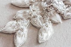 Nostalgic of precious jewelry, each MillieIcaro Sash is made from pearls, mounted swarovski crystals, and silk thread. Beautifully intricate, each sash emanates old Hollywood Glamor and vintage feel making it both luscious and trendy. A prefect bridal belt to add on a simple wedding dress to add shimmer. * Offwhite fabric work with silver beading and swarovski rhinestones* The beaded section is about 14.5 inch in length with a max width in the center about 4 inches. This tapers on either side to Elegant Embellished Sashes, Elegant Beaded Silver Sashes, Elegant Silver Beaded Sash, Elegant Embellished Sashes For Party, Elegant Silver Bridal Belt With Pearl Embroidery, Wedding Belts And Sashes, Flowers And Crystals, Hollywood Glamor, Wedding Sash Belt