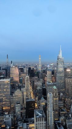 an aerial view of the city at night with skyscrapers and other tall buildings in the background