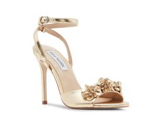 Steve Madden Floral - Women's Sandals : Gold : The Steve Madden Floral sandals combine feminine charm with trendy flair, featuring delicate floral embellishments adorning the toe strap. These heeled sandals are designed with a rubber upper that features an ankle strap with an adjustable buckle closure. The rubber insole and synthetic rubber lining provide added comfort. With sturdy stiletto heels and a comfortable design, these heels are an ideal choice for adding a touch of elegance to any outfit. Open, round toe silhouette. Synthetic rubber outsole. Made in Brazil. Measurements: Heel Height: 4 1 4 in Weight: 10.4 oz Product measurements were taken using size 7, width M. Please note that measurements may vary by size. Gold Heels Steve Madden, Glamorous Gold Sandals With 4-inch Heel, Gold Sandals With 4-inch Heel Medium Width, High Heel Sandals With Gold-tone Hardware For Parties, Gold High Heel Mules With 4-inch Heel, Floral Sandals, Top Backpacks, Synthetic Rubber, Steve Madden