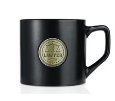 a black coffee mug with the word law on it and a gold seal in the center