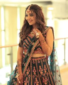 a woman in a blue and green lehenga