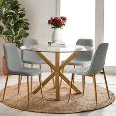 a glass table with four chairs around it and a potted plant in the corner