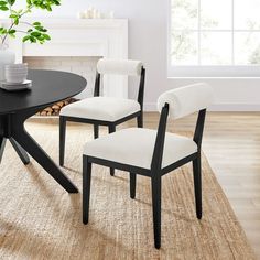 a black table with two white chairs and a potted plant