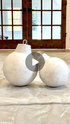 two large white balls sitting on top of a floor