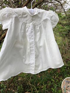 1960s Sorbeau white cotton infant dress: This little dress looks to be a 3-6 mo. in size. It is collared with lace trimmed puff sleeves. It also has dainty white floral embroidery and an organdy floral ribbon front. The hem is scalloped and lace trimmed. It includes a matching bonnet. Measurements: Across shoulders 8 in. Length 17 in. White Short Sleeve Baptism Dress For Daywear, White Baptism Dress With Short Sleeves For Daywear, Cotton Baptism Dress With Short Sleeves For Daywear, Fitted Cotton Baptism Dress With Lace Trim, Cotton Short Sleeve Baptism Dress, Fitted Baptism Dress With Lace Trim For Daywear, Fitted Baptism Dress With Lace Trim, Cotton Baptism Dress With Short Sleeves, White Cotton Baptism Dress With Broderie Anglaise